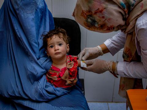 World Vision staff in Afghanistan checks the nutrition status of young child in World Vision Supported Clinic